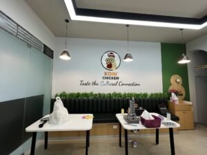 Koin Chicken acrylic logo and tagline on restaurant wall