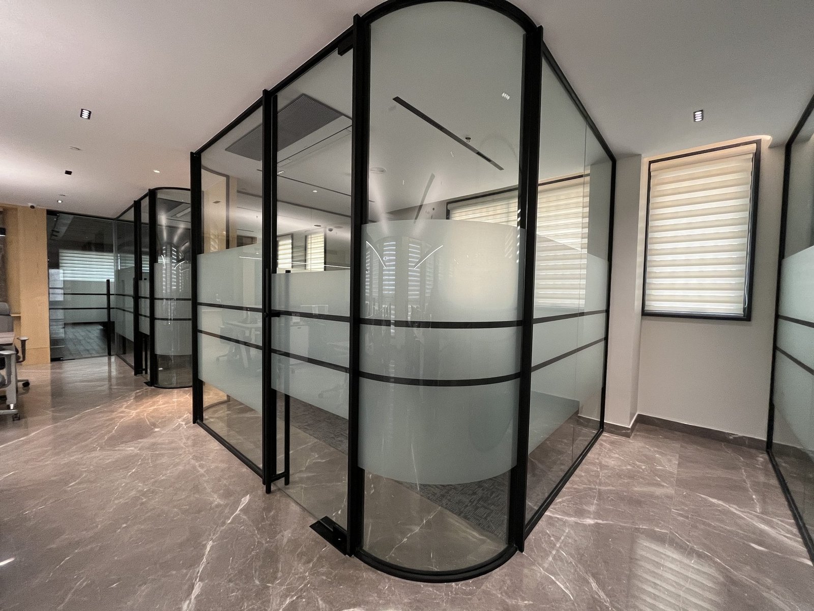 Curved glass partition cabin with banded frosted film