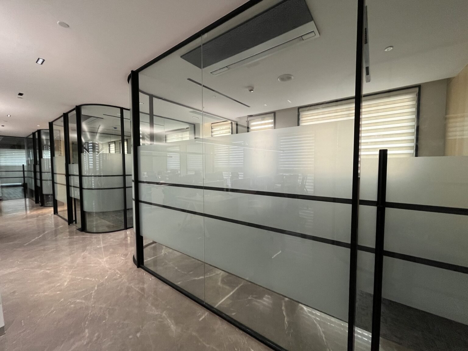 Framed glass office partition with frosted film banding