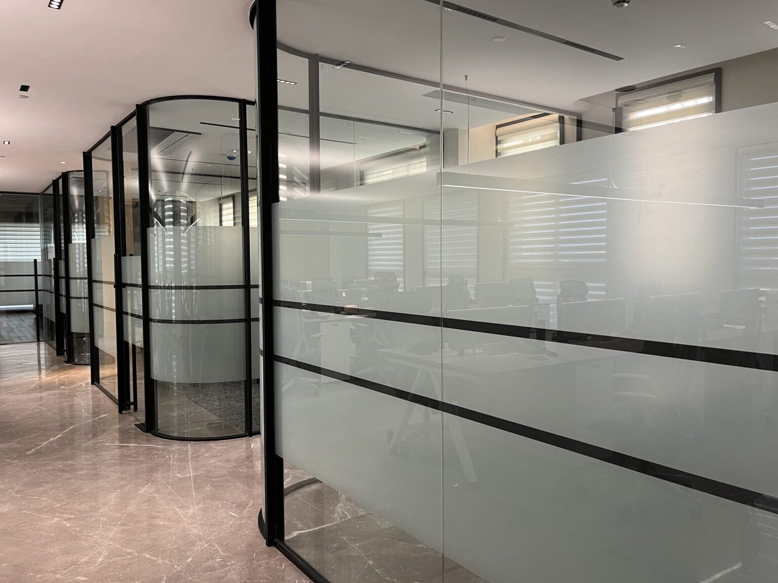 Framed glass office partition with frosted film banding