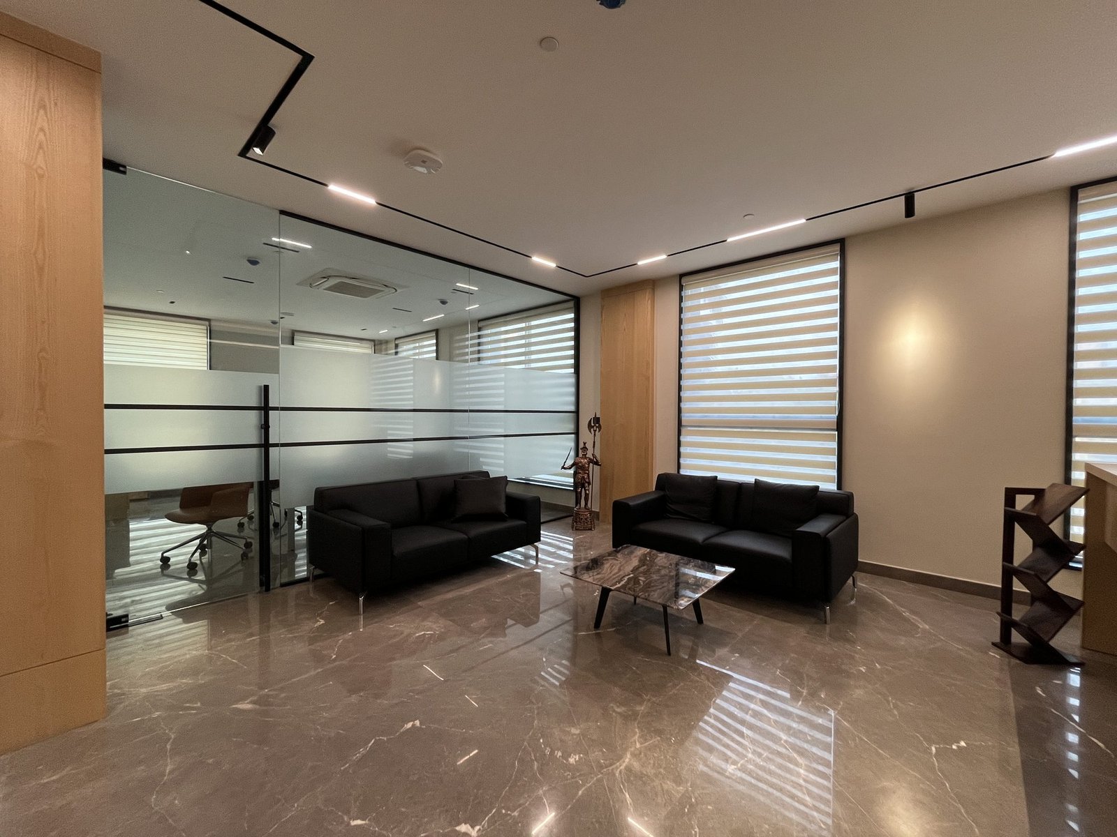 Office lounge behind full-height glass partitions