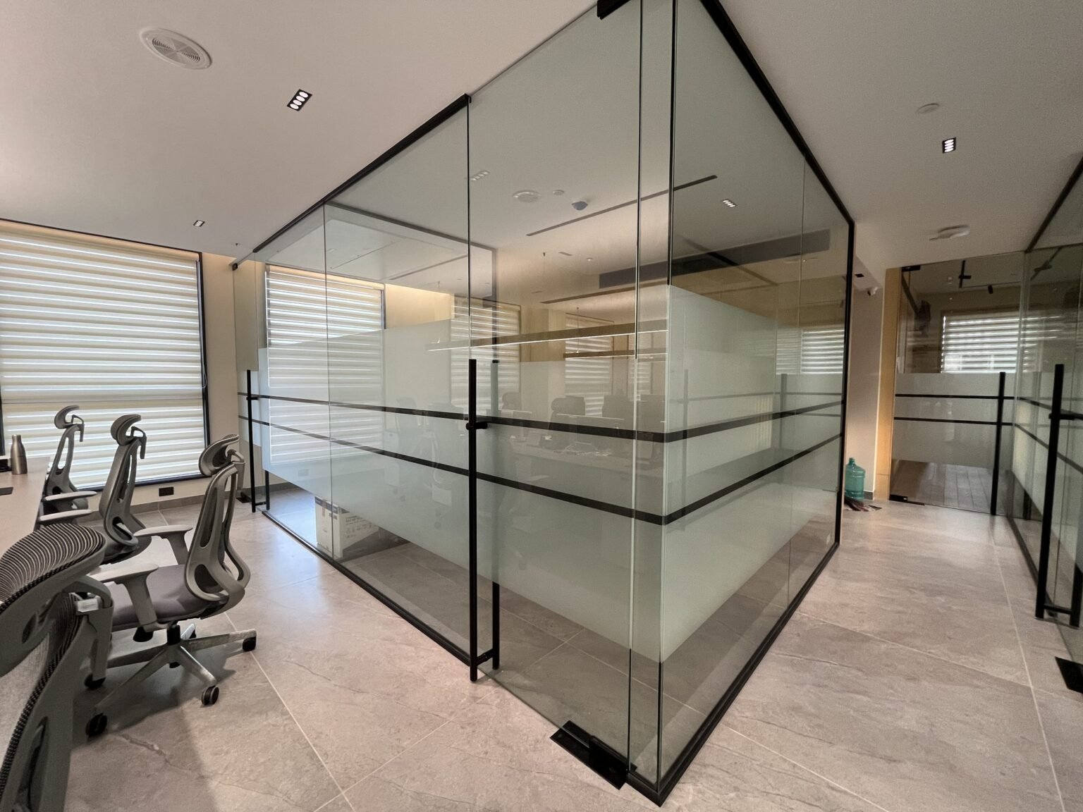 Framed glass office partition with frosted film banding