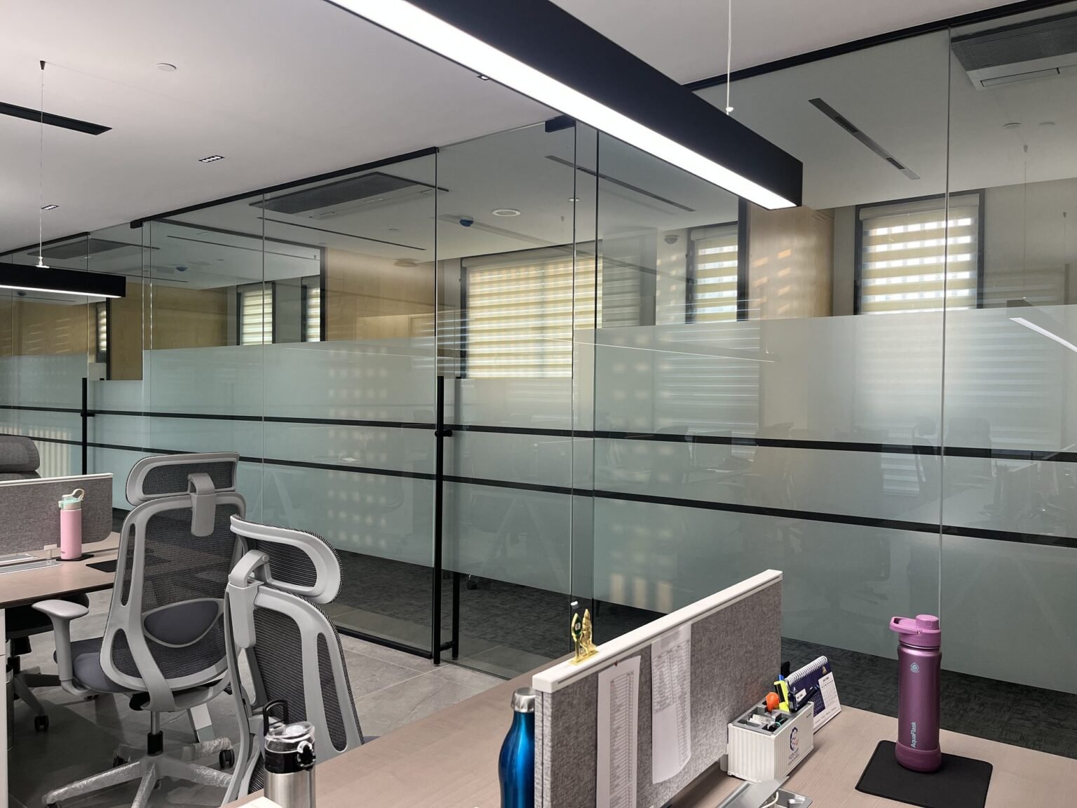 Framed glass office partition with frosted film banding