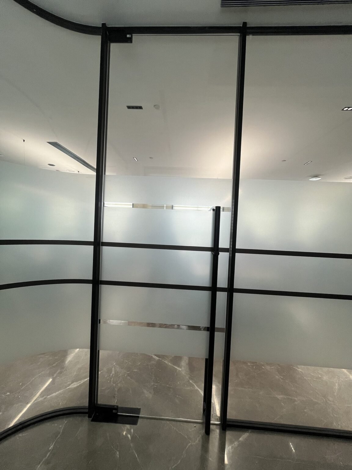 Frosted film banding detail on framed glass partition