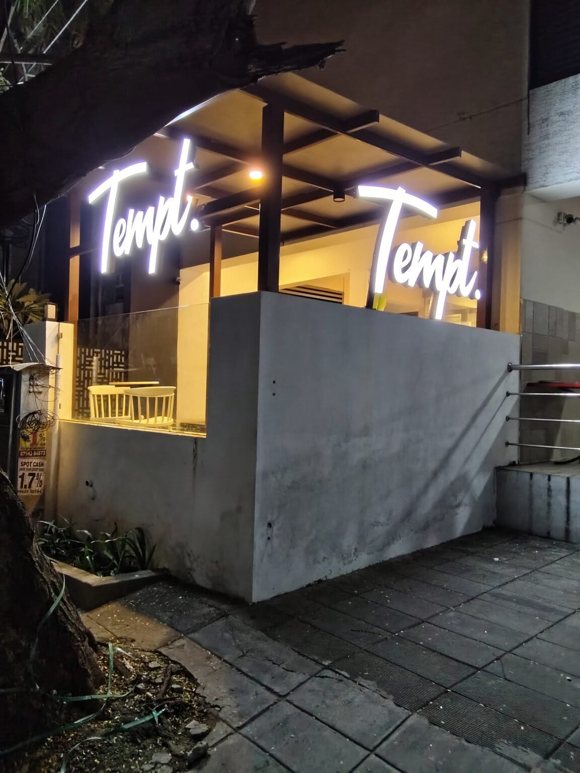 Tempt. illuminated glow letters on the terrace elevation at night