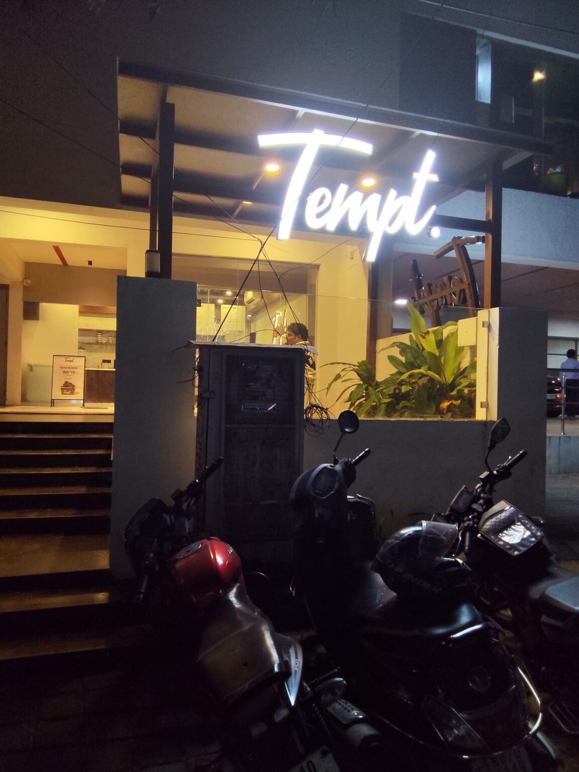 Tempt. illuminated script signage at the cafe entrance