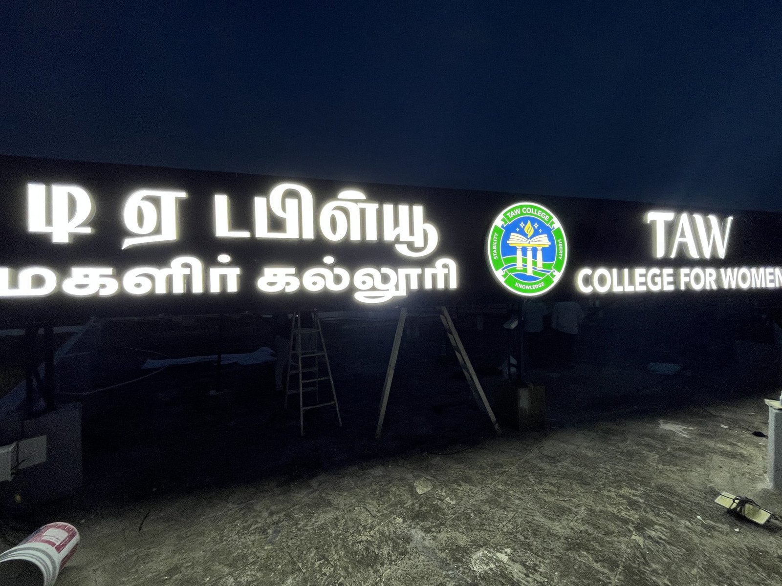 TAW College for Women illuminated trimcap signage at night